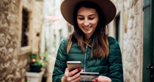 Girl using cell phone to pay for something while travelling